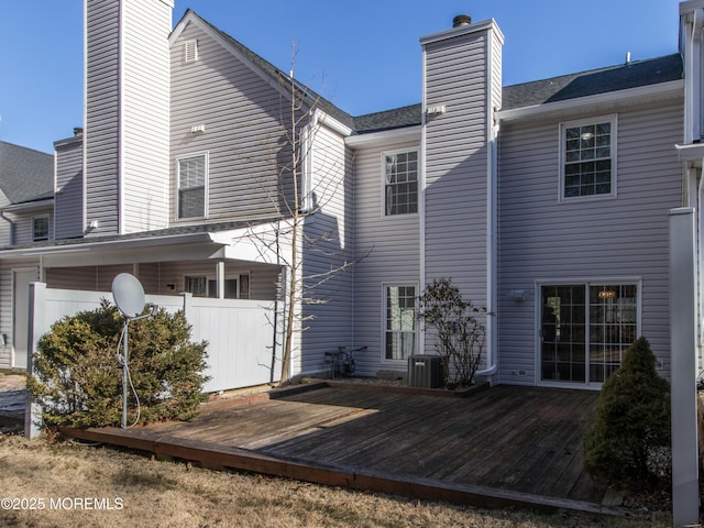 back of house with central air condition unit, a chimney, and a deck