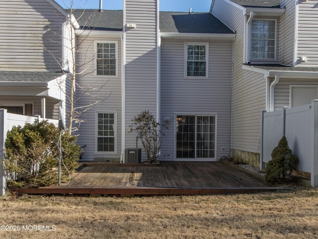 back of house featuring central AC, a chimney, a wooden deck, and fence