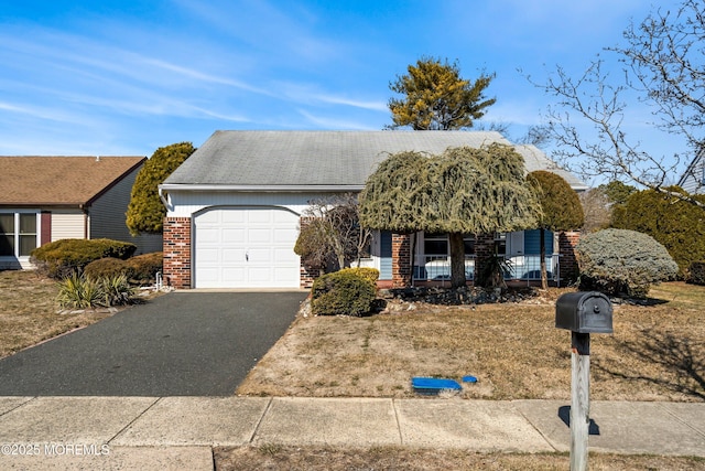 view of front facade with an attached garage, a porch, aphalt driveway, and brick siding