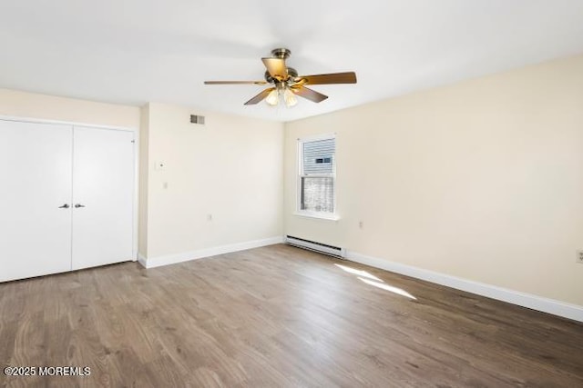 unfurnished bedroom with baseboard heating, visible vents, and baseboards