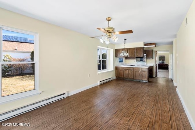 kitchen featuring dark wood-style floors, baseboards, a baseboard heating unit, and light countertops