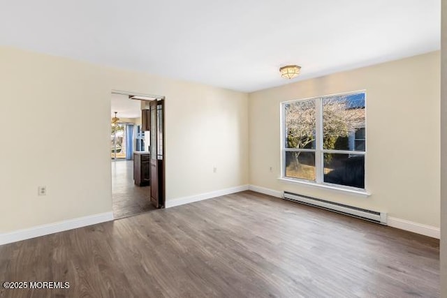 unfurnished room featuring a healthy amount of sunlight, baseboards, baseboard heating, and wood finished floors