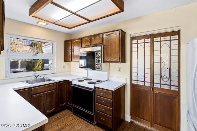 kitchen with stainless steel microwave, electric range oven, a sink, and light countertops