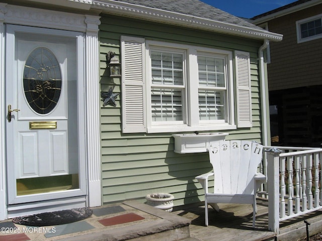 view of side of property with roof with shingles