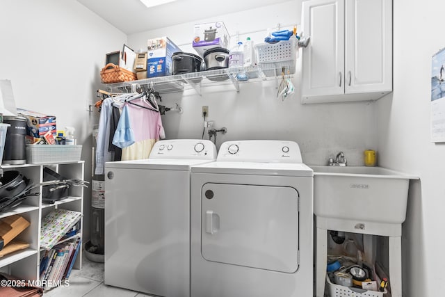 washroom with a sink, cabinet space, and washer and dryer