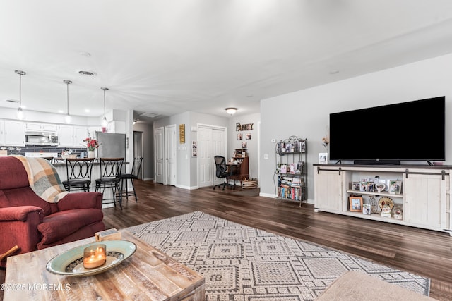 living area with dark wood-style floors, visible vents, and baseboards