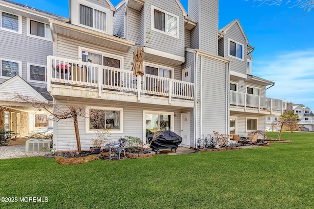 back of house featuring a patio area, a chimney, central AC unit, and a lawn