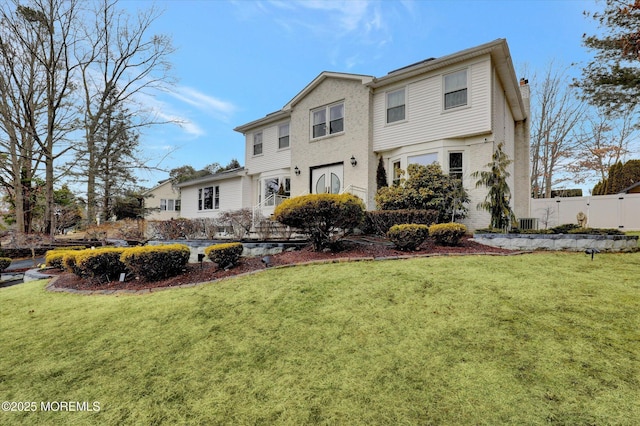 view of front of house with a chimney, fence, and a front yard