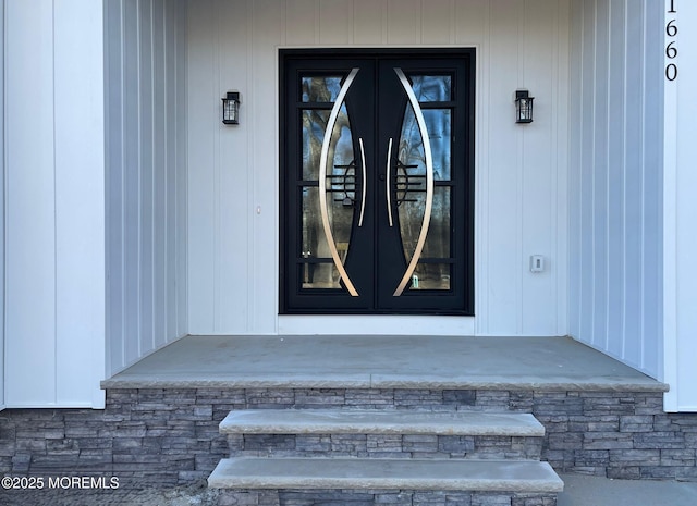 property entrance featuring stone siding and french doors