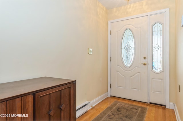 foyer entrance with light wood-type flooring, a baseboard heating unit, and baseboards