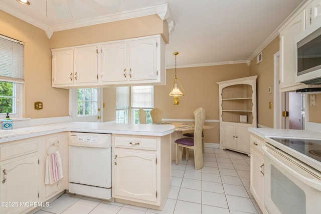 kitchen featuring a wealth of natural light, white appliances, a peninsula, and crown molding