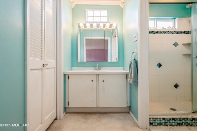 full bathroom with tiled shower and vanity