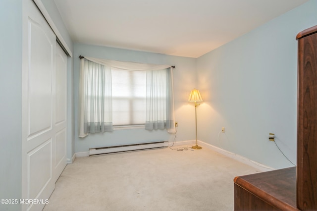 interior space with a baseboard heating unit, carpet, baseboards, and a closet