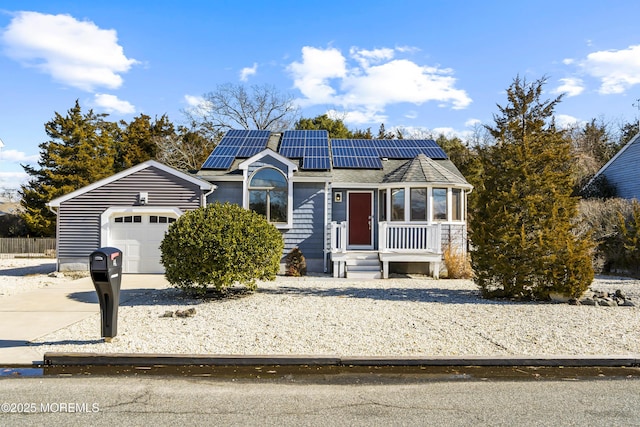 view of front of home featuring a garage, solar panels, a shingled roof, and concrete driveway