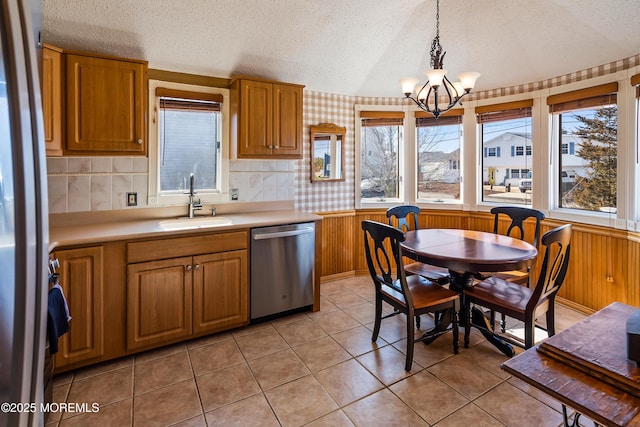 kitchen featuring stainless steel appliances, plenty of natural light, light countertops, and a sink