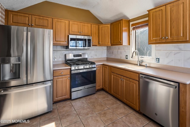 kitchen featuring appliances with stainless steel finishes, light countertops, and a sink