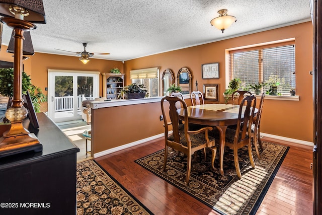 dining space with a healthy amount of sunlight, hardwood / wood-style flooring, ceiling fan, and baseboards