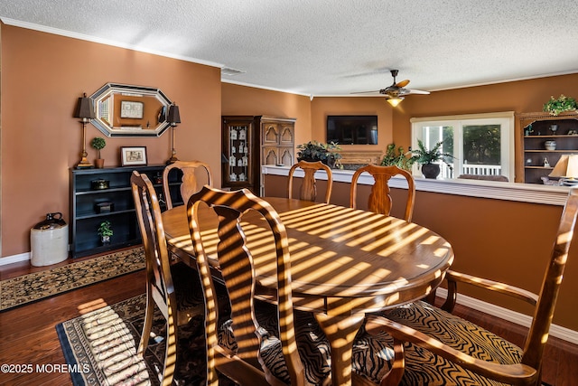 dining area featuring a ceiling fan, ornamental molding, a textured ceiling, wood finished floors, and baseboards