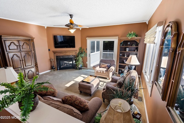 living room featuring light carpet, ceiling fan, a premium fireplace, crown molding, and a textured ceiling