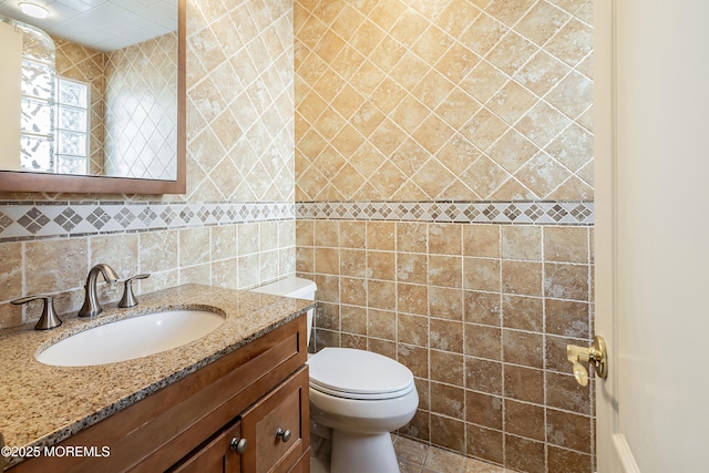 half bath with toilet, vanity, tile walls, and decorative backsplash