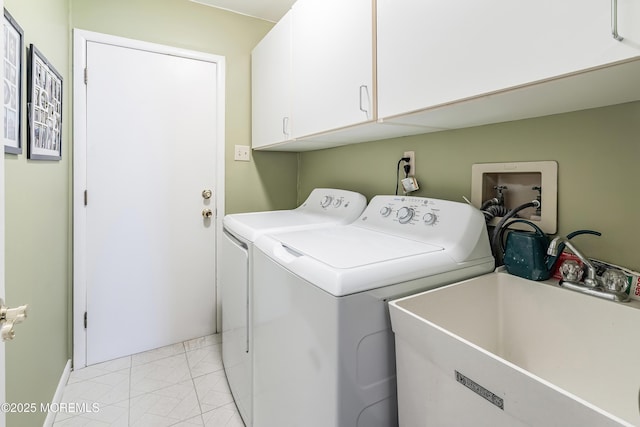 washroom with washing machine and clothes dryer, a sink, and cabinet space