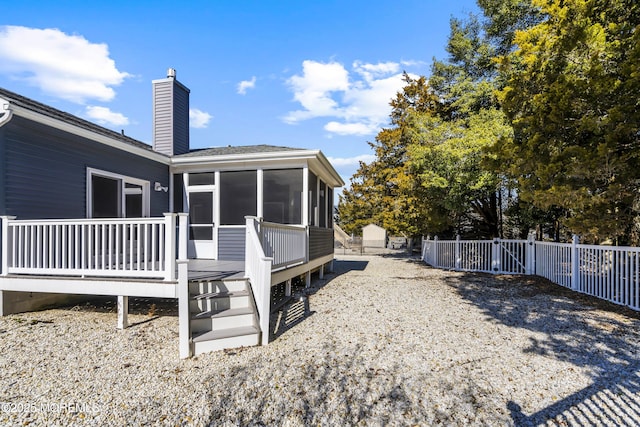 back of property featuring a sunroom, fence, and a chimney