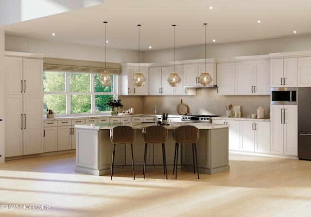 kitchen with stainless steel appliances, tasteful backsplash, a center island with sink, and white cabinets