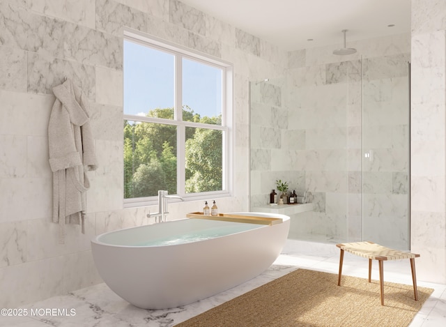 full bathroom featuring a walk in shower, marble finish floor, a freestanding tub, and tile walls