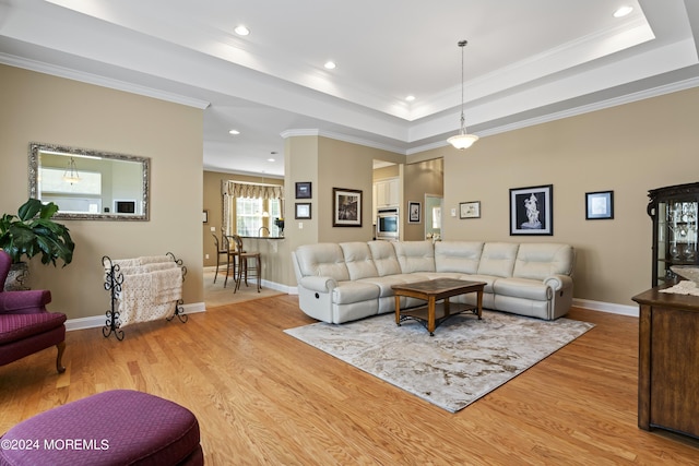 living room featuring a tray ceiling, crown molding, recessed lighting, wood finished floors, and baseboards