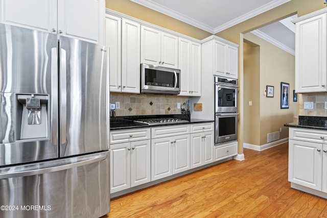 kitchen featuring stainless steel appliances, white cabinetry, light wood-type flooring, decorative backsplash, and crown molding