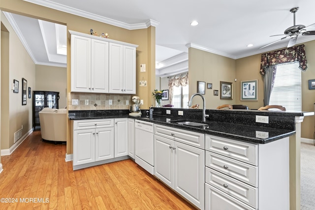 kitchen featuring dishwasher, ornamental molding, backsplash, a peninsula, and a sink