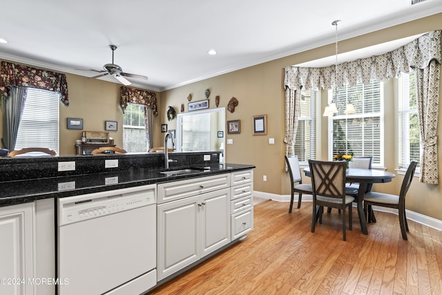 kitchen featuring a sink, baseboards, ornamental molding, dishwasher, and light wood finished floors