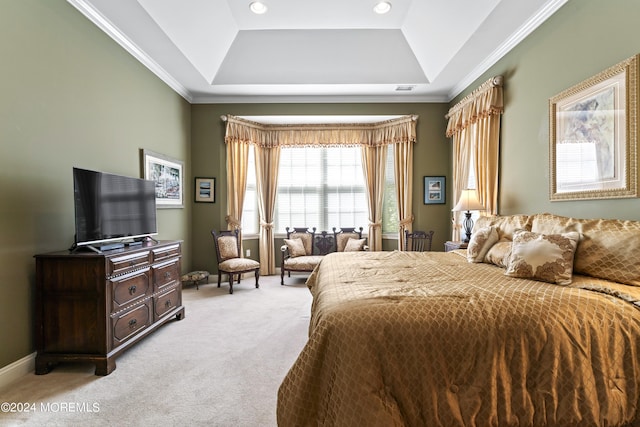 bedroom with baseboards, ornamental molding, a tray ceiling, and light colored carpet