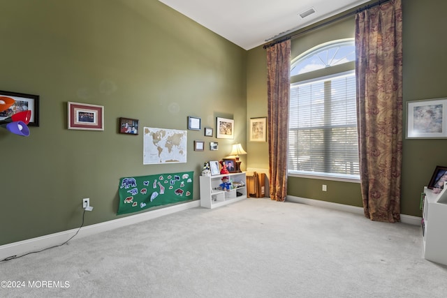 game room with carpet flooring, plenty of natural light, visible vents, and baseboards