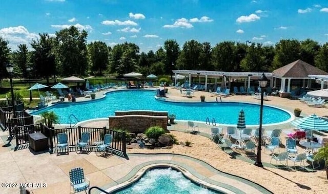 pool with a patio and a pergola