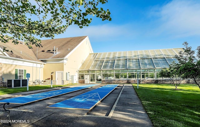 surrounding community featuring shuffleboard and a yard