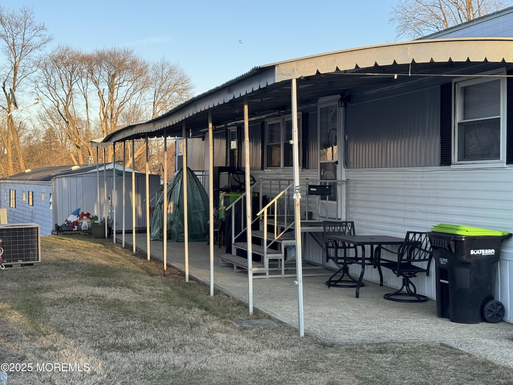 view of patio featuring an outdoor structure, a storage shed, and central AC unit