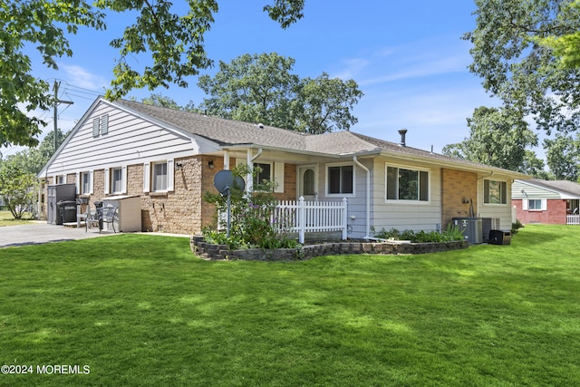 ranch-style home featuring driveway, central AC unit, a front lawn, and brick siding