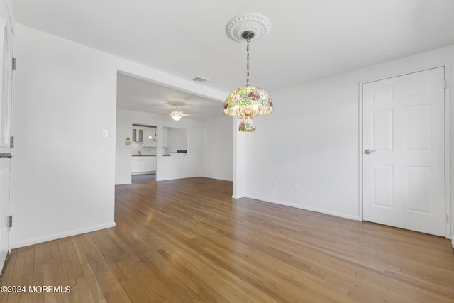 interior space featuring visible vents, a notable chandelier, light wood-style flooring, and baseboards