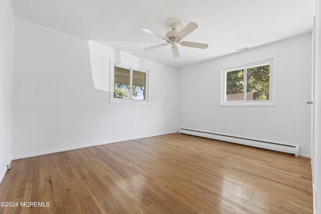 unfurnished room featuring a baseboard radiator, wood-type flooring, visible vents, and baseboards