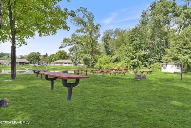 view of property's community featuring a yard and an outdoor structure