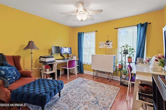 office space featuring ceiling fan, baseboards, and wood finished floors