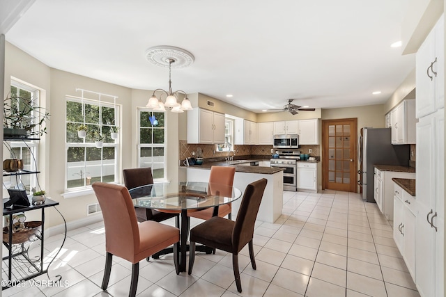 dining area featuring recessed lighting, light tile patterned flooring, and a healthy amount of sunlight