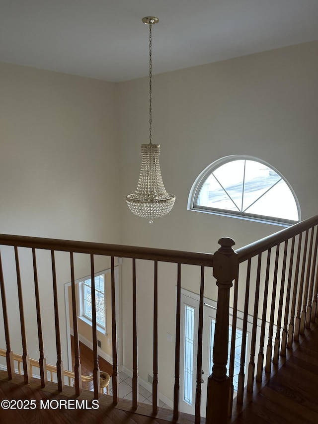 stairs with a notable chandelier