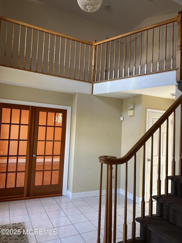 stairs with tile patterned flooring, a high ceiling, baseboards, and french doors