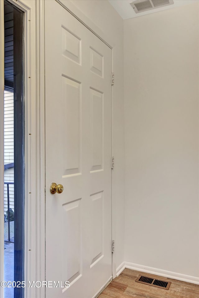 interior space with wood finished floors, visible vents, and baseboards