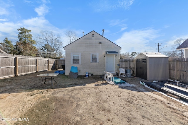 rear view of house featuring a storage unit, an outbuilding, and a fenced backyard