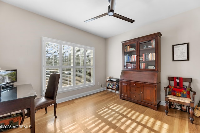 office area featuring ceiling fan, light wood finished floors, visible vents, and baseboards