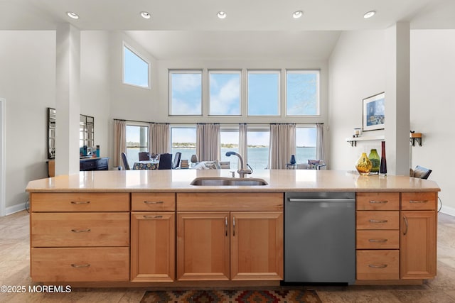 kitchen with baseboards, a high ceiling, a sink, and stainless steel dishwasher