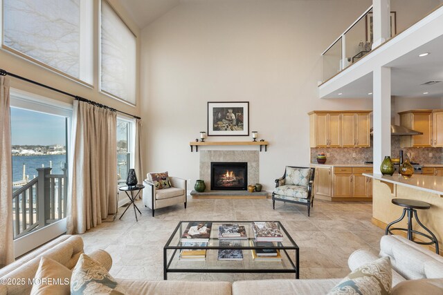 living room featuring a high ceiling, a fireplace, and visible vents